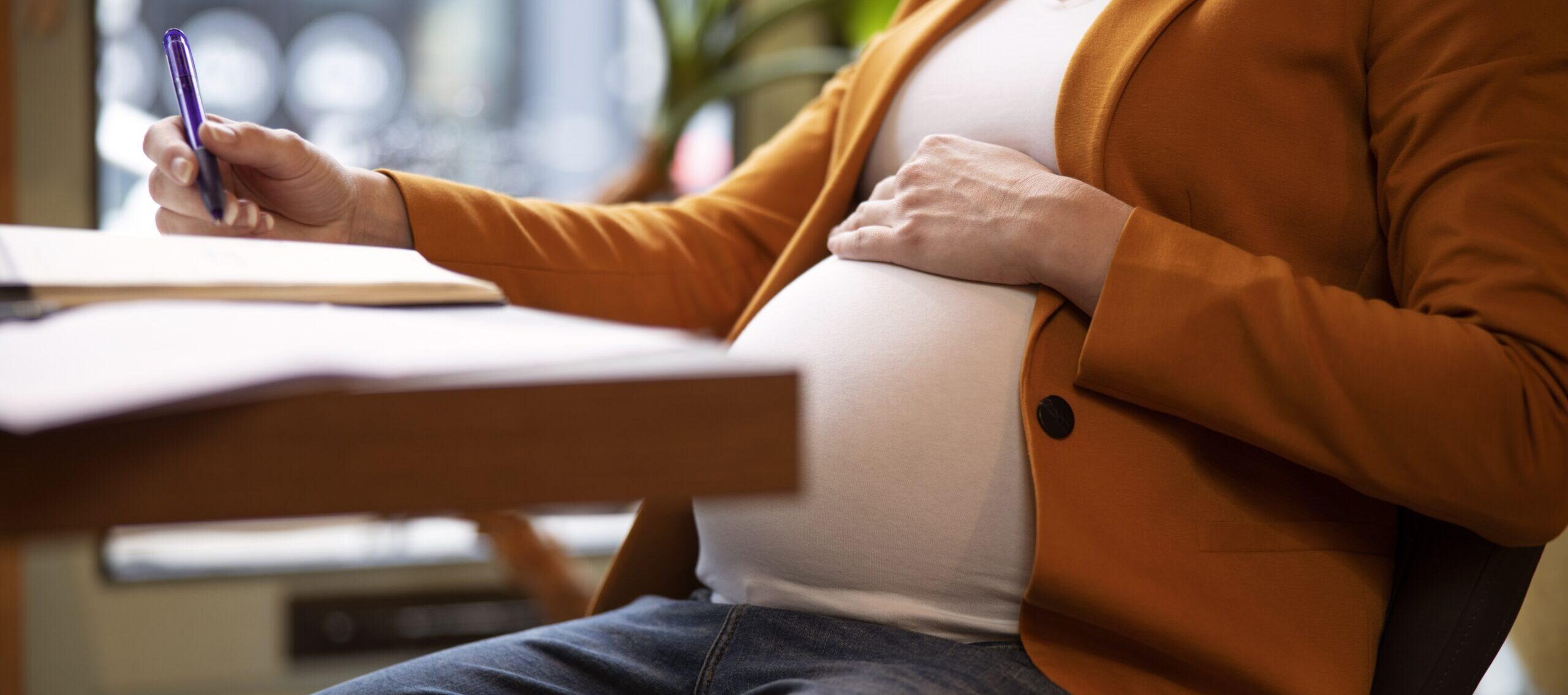 photo femme enceinte travaillant assise au bureau